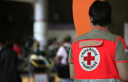 5月2日,在法國巴黎的戴高樂機場,一名法國紅十字會的工作人員等待來自墨西哥的旅客領(lǐng)取行李。新華社記者 張玉薇 攝
